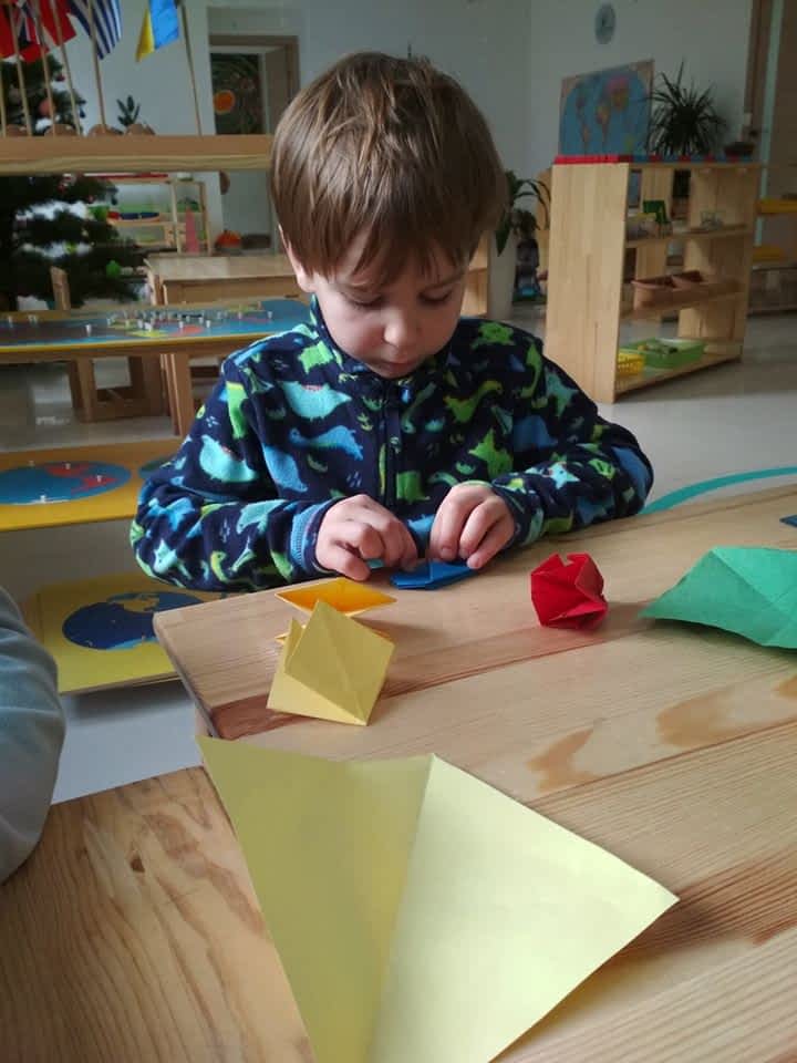 Мальчик делает оригами